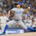 A Chicago Cubs pitcher in a grey uniform throws a baseball.