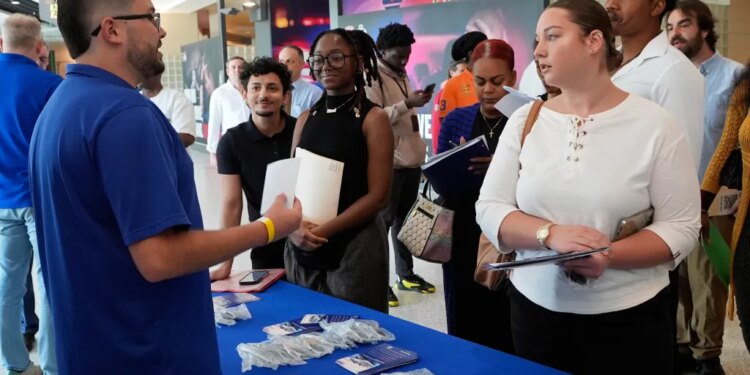 Job seekers listening to Logan Reed, a talent acquisition coordinator for Princess Cruise Line, at a job fair.