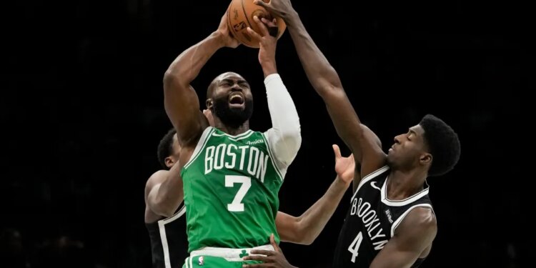 Boston Celtics guard Jaylen Brown (7) attempts to pass away from Brooklyn Nets guard Drake Powell (4) during the second half of an NBA basketball game, Tuesday, Nov. 18, 2025, in New York.