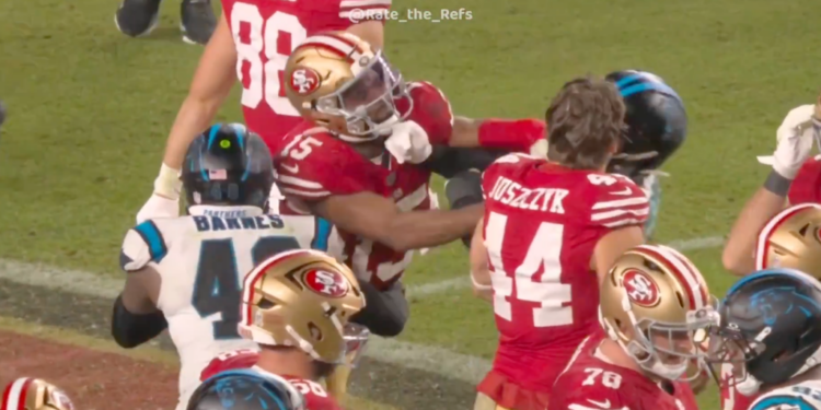 Jauan Jennings punching an opponent during a football game.