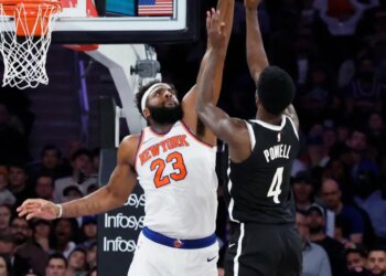Mitchell Robinson blocking Drake Powell's shot during a game.