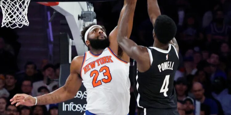 Mitchell Robinson blocking Drake Powell's shot during a game.