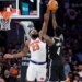 Mitchell Robinson blocking Drake Powell's shot during a game.