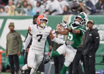 Tyson Campbell and Garrett Wilson watching an incomplete pass.