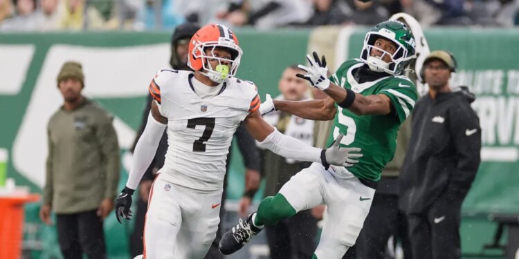 Tyson Campbell and Garrett Wilson watching an incomplete pass.
