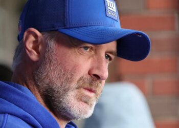 A man in a blue New York Giants hat looking to his right.