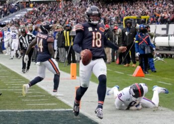 Chicago Bears quarterback Caleb Williams (18) scores a touchdown against New York Giants linebacker Brian Burns (0).