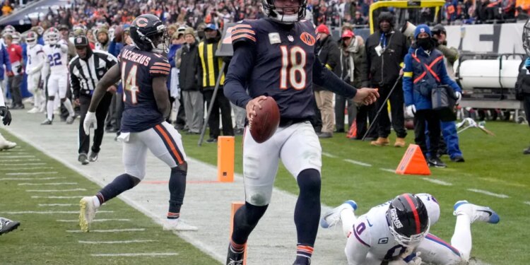Chicago Bears quarterback Caleb Williams (18) scores a touchdown against New York Giants linebacker Brian Burns (0).