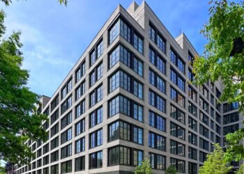 499 President Street in Gowanus, Brooklyn, a modern gray brick building with multiple large windows, with cars parked on the street in front and trees lining the street.