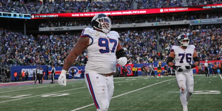 New York Giants defensive tackle Dexter Lawrence II (97) and guard Jon Runyan (76) walk off the field after the Giants gave up a 2-point conversion.