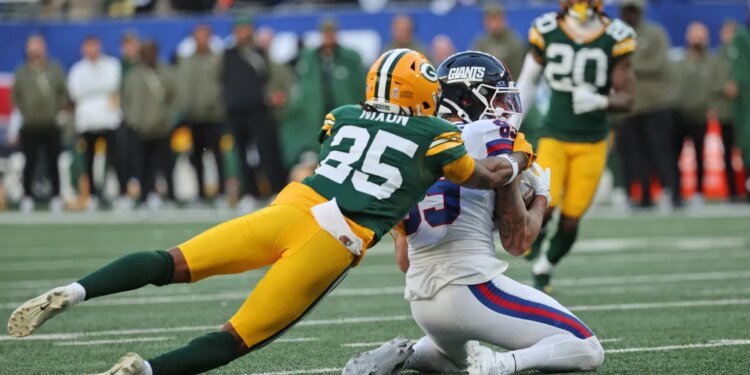 Green Bay Packers player (25) tackling New York Giants wide receiver Isaiah Hodgins (89) in the 4th quarter.