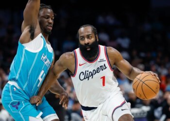 Los Angeles Clippers guard James Harden drives to the basket against Charlotte Hornets guard Sion James.