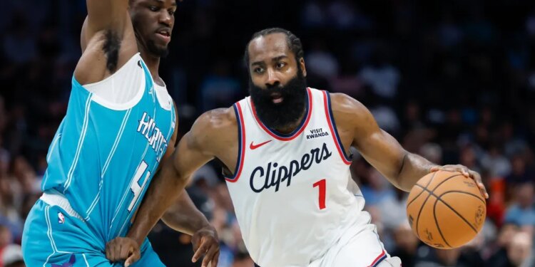 Los Angeles Clippers guard James Harden drives to the basket against Charlotte Hornets guard Sion James.