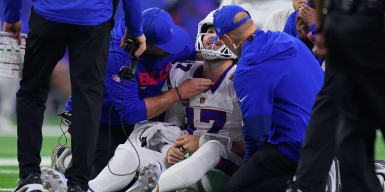 Buffalo Bills quarterback Josh Allen is attended to by medical staff after being sacked by Will Anderson Jr.