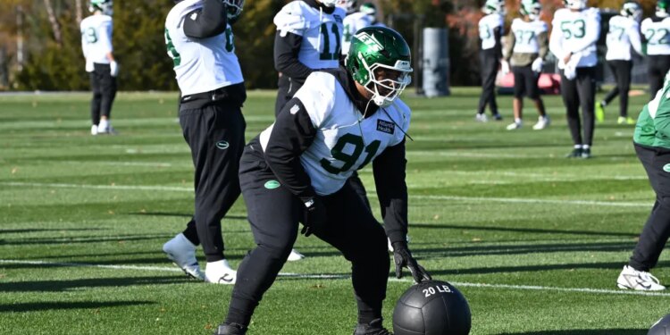 Jets defensive end Jowon Briggs (91) rolls a medicine ball during practice.