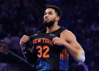 NBA player Karl-Anthony Towns stretches his jersey during a game.