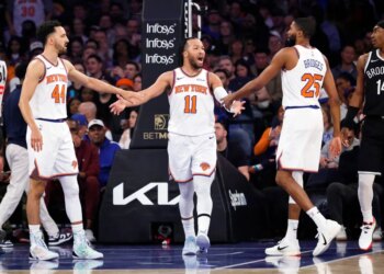 Jalen Brunson of the New York Knicks is greeted by Landry Shamet and Mikal Bridges after scoring.