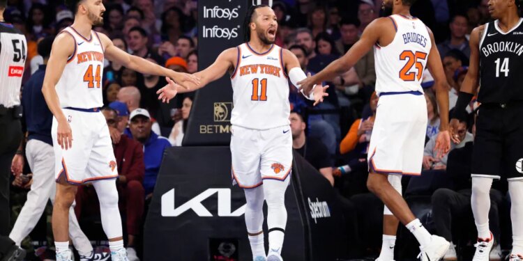 Jalen Brunson of the New York Knicks is greeted by Landry Shamet and Mikal Bridges after scoring.