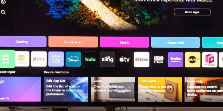 The LG G5 OLED TV on a wooden home theater cedenza display the webOS home screen.