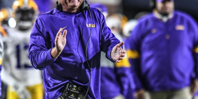LSU coach Ed Orgeron smiles and claps during a game.