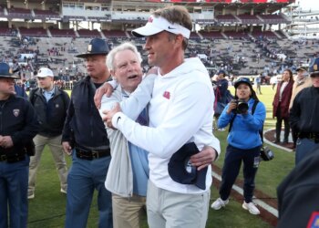 Mississippi Rebels head coach Lane Kiffin embraces chancellor Glenn Boyce after defeating the Mississippi State Bulldogs.