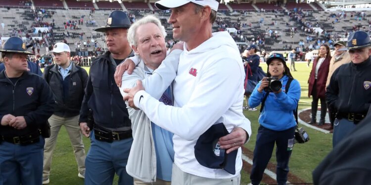 Mississippi Rebels head coach Lane Kiffin embraces chancellor Glenn Boyce after defeating the Mississippi State Bulldogs.
