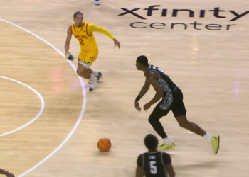 Myles Rice, with his right shoe in hand, runs towards Georgetown's Vince Iwuchukwu to try to cause a defensive stop or steal on Friday night.