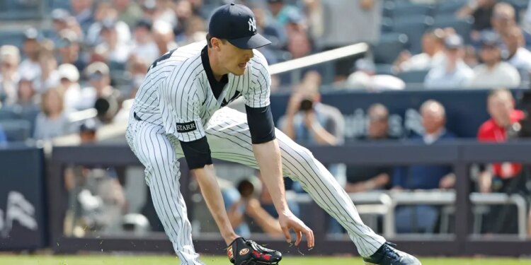 New York Yankees pitcher Max Fried makes a throwing error on a ball hit by Milwaukee Brewers outfielder Christian Yelich allowing Yelich to safely reach first and a run scored during the second inning at Yankee Stadium in the Bronx, New York, USA, Saturday, March 29, 2025.