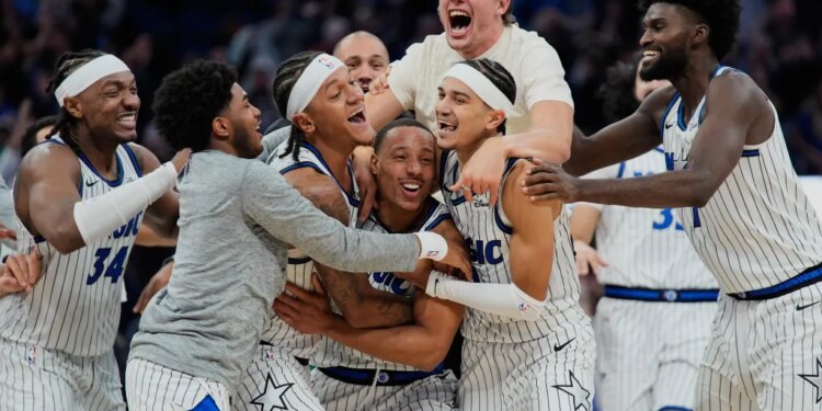 Orlando Magic guard Desmond Bane, center, celebrates with teammates after making a game winning shot against the Portland Trail Blazers.