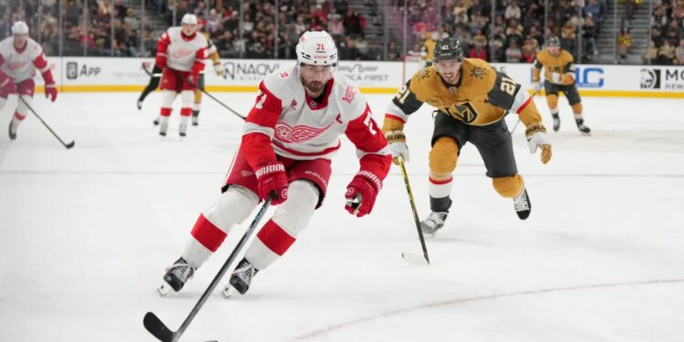 Detroit Red Wings center Dylan Larkin (71) skates with the puck against Vegas Golden Knights center Brett Howden (21) during a hockey game.