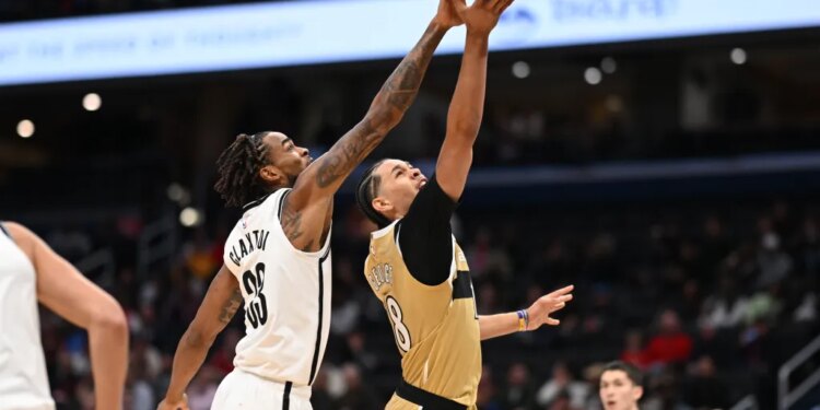 Brooklyn Nets center Nic Claxton (33) blocks a shot by Washington Wizards forward Kyshawn George (18).