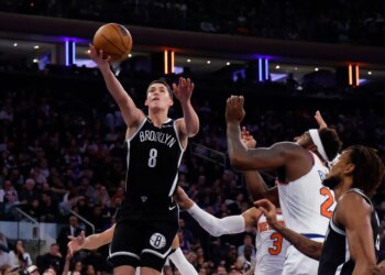 Brooklyn Nets guard Egor Demin shoots over New York Knicks defenders.
