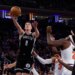 Brooklyn Nets guard Egor Demin shoots over New York Knicks defenders.