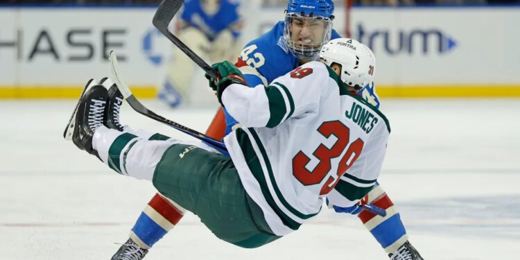 Noah Laba checks Minnesota Wild center Ben Jones to the ice in the third period at Madison Square Garden in New York, October 20, 2025.