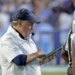 North Carolina head coach Bill Belichick checking his tablet during a football game.