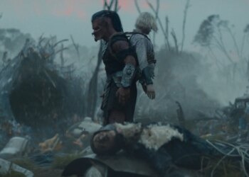 A Yautja alien with a humanoid robot missing her legs strapped to its back.