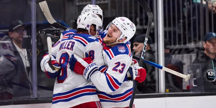 New York Rangers players Adam Fox (23) and J.T. Miller (8) celebrate a win against the Seattle Kraken.