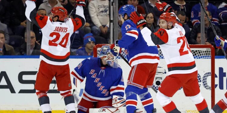 Carolina Hurricanes center Seth Jarvis celebrates a goal with teammate Andrei Svechnikov as New York Rangers goalie Igor Shesterkin and defenseman K'Andre Miller react.