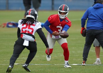 New York Giants quarterback Russell Wilson #3 handing the ball off to running back Dante Miller #25 during practice.