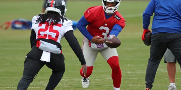 New York Giants quarterback Russell Wilson #3 handing the ball off to running back Dante Miller #25 during practice.