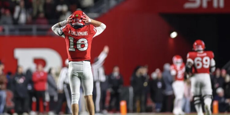 Rutgers quarterback Athan Kaliakmanis reacting to a play with his hands on his helmet.