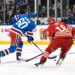 New York Rangers defenseman Scott Morrow (60) skates with the puck while defended by Detroit Red Wings center Andrew Copp (18).
