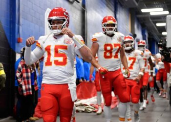 Patrick Mahomes, Travis Kelce, and other Kansas City Chiefs players walking in a hallway.