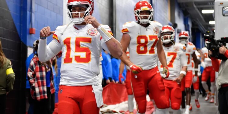 Patrick Mahomes, Travis Kelce, and other Kansas City Chiefs players walking in a hallway.