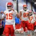 Patrick Mahomes, Travis Kelce, and other Kansas City Chiefs players walking in a hallway.