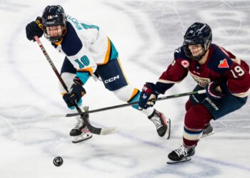 New York Sirens' Maddi Wheeler (18) and Montréal Victoire's Kaitlin Willoughby (19) vie for the puck in a hockey game.