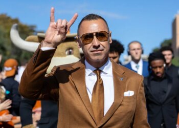 Texas coach Steve Sarkisian flashing the "Hook 'Em Horns" sign.