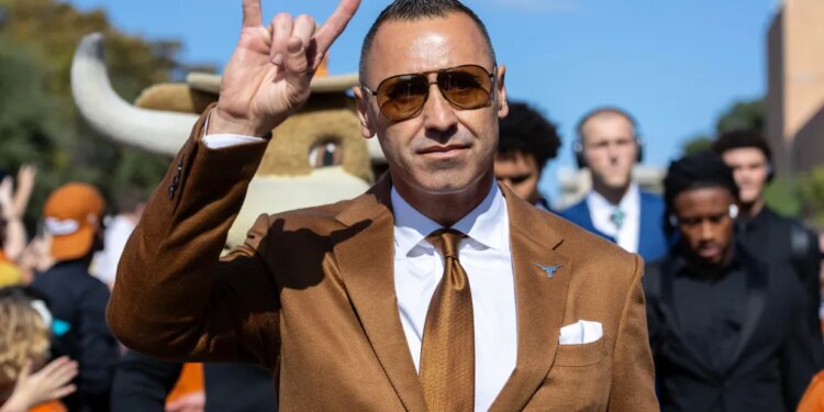 Texas coach Steve Sarkisian flashing the "Hook 'Em Horns" sign.