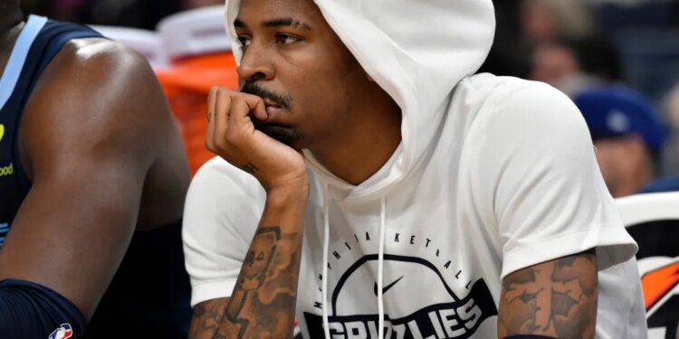 Ja Morant looks on from the bench during an NBA basketball game.