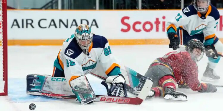 New York Sirens goaltender Kayle Osborne (82) watches the puck as Ottawa Charge's Brianne Jenner (19) slides along the ice.